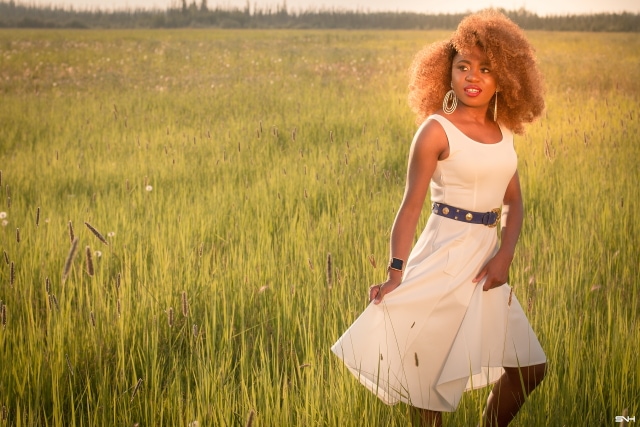 Can't get over her stunning white summer dress! ? Twirling in the prairie fields. Her sleeveless A-line midi dress has the perfect flare. Bold statement hoop earrings and embellished blue belt perfects her outfit. A dress that you can dress up or down! Little white dress, flare dress, Dress with flare, White dress, Summer dress, Formal dress, Modest dress, Wedding guest outfit, Black girl, Classy dress, womens style