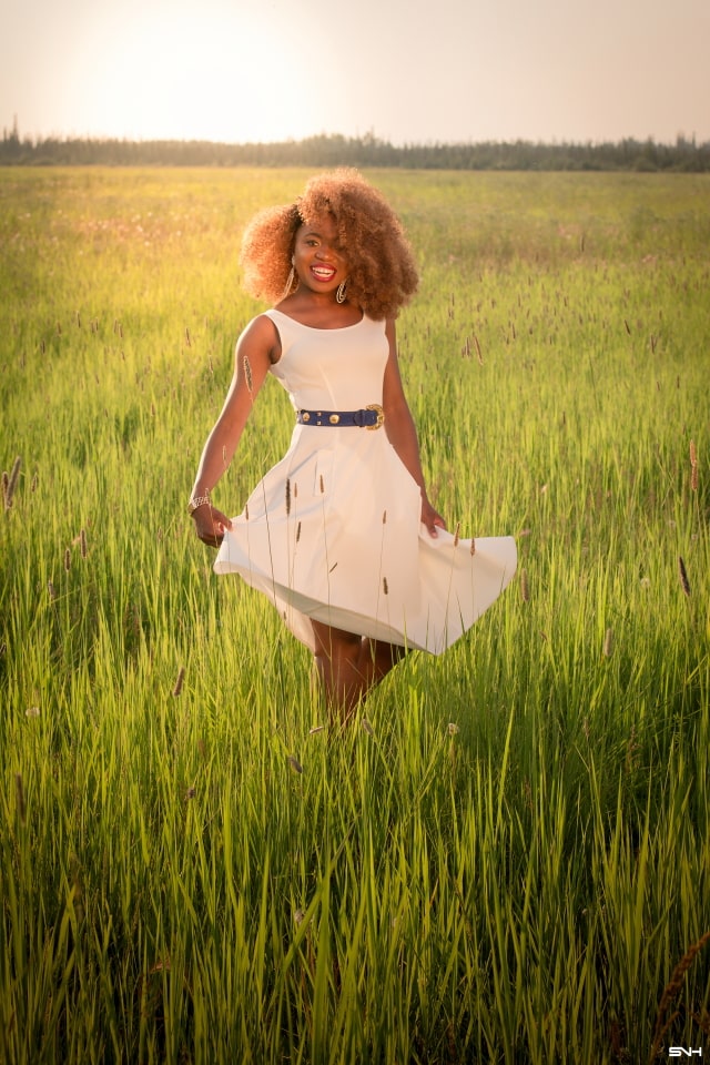 Can't get over her stunning white summer dress! ? Twirling in the prairie fields. Her sleeveless A-line midi dress has the perfect flare. Bold statement hoop earrings and embellished blue belt perfects her outfit. A dress that you can dress up or down! Little white dress, flare dress, Dress with flare, White dress, Summer dress, Formal dress, Modest dress, Wedding guest outfit, Black girl, Classy dress, womens style