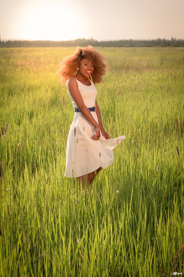 Can't get over her stunning white summer dress! ? Twirling in the prairie fields. Her sleeveless A-line midi dress has the perfect flare. Bold statement hoop earrings and embellished blue belt perfects her outfit. A dress that you can dress up or down! Little white dress, flare dress, Dress with flare, White dress, Summer dress, Formal dress, Modest dress, Wedding guest outfit, Black girl, Classy dress, womens style