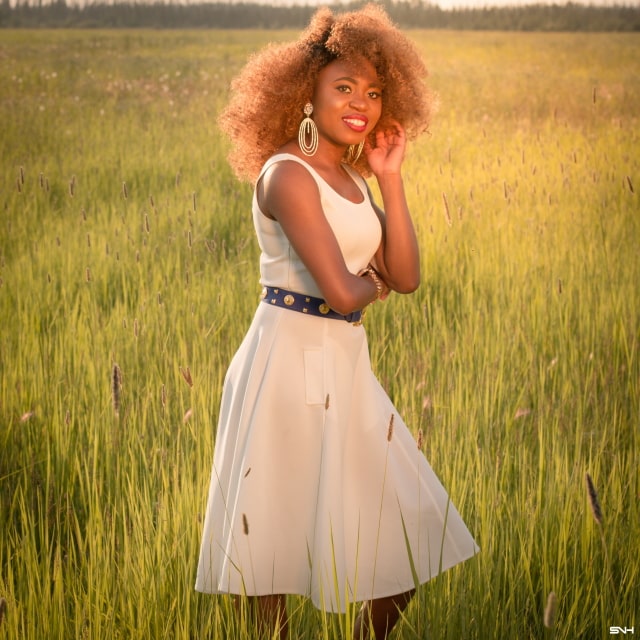 Can't get over her stunning white summer dress! ? Twirling in the prairie fields. Her sleeveless A-line midi dress has the perfect flare. Bold statement hoop earrings and embellished blue belt perfects her outfit. A dress that you can dress up or down! Little white dress, flare dress, Dress with flare, White dress, Summer dress, Formal dress, Modest dress, Wedding guest outfit, Black girl, Classy dress, womens style