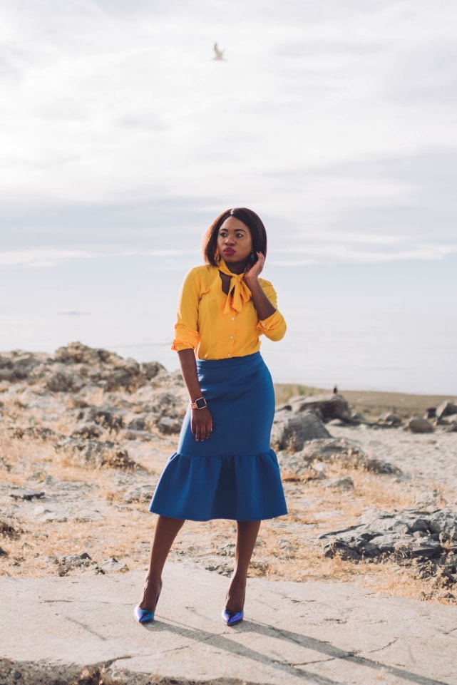 Never thought blue & yellow would look this good! Very work appropriate and stylish with the neck tie bow and peplum midi skirt. ?? Work style, dressy outfit, women's style, black girl, Nigerian blogger, pussy bow top, neoprene skirt, iridescent hologram heels