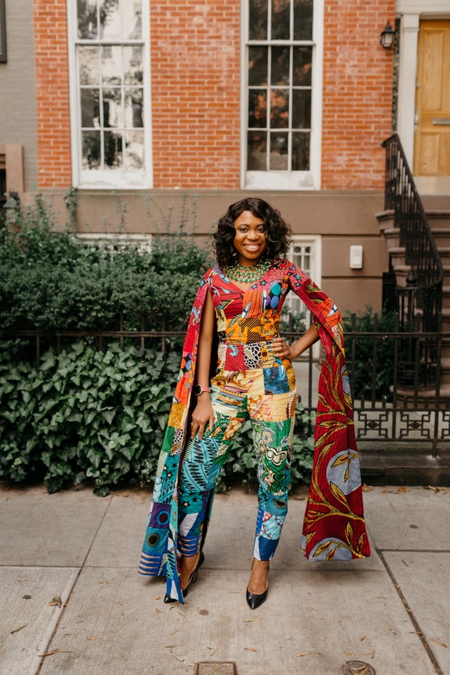 How I love the dramatic cape sleeves of this rainbow patchwork ankara jumpsuit. I'm sure she turned heads when she showed up to New York Fashion Week dressed like this. With simple wavy hair, black pumps and green statement necklace to match, it'll be no surprise if the media swoons over her. Stunning New York Fashion Week Fall/Winter 2017 outfit #NYFW #ootd #Ankara #Kente