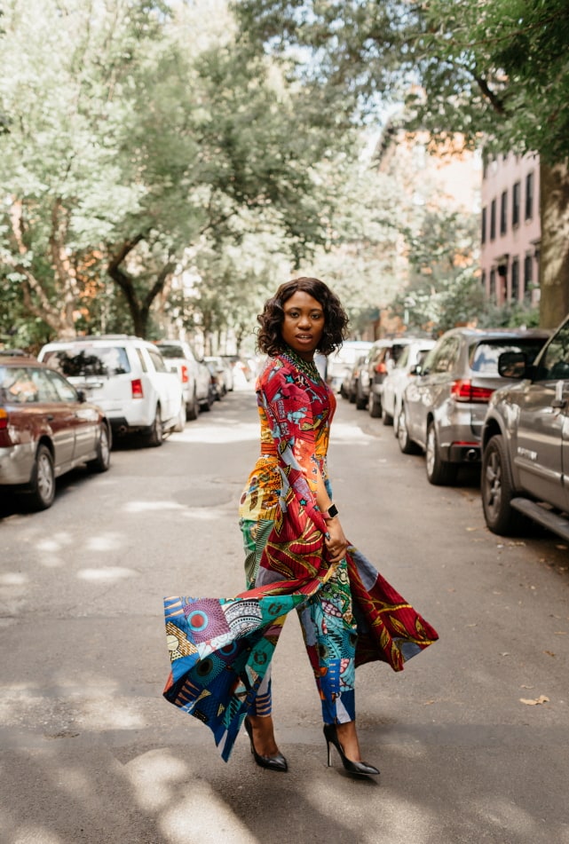 How I love the dramatic cape sleeves of this rainbow patchwork ankara jumpsuit. I'm sure she turned heads when she showed up to New York Fashion Week dressed like this. With simple wavy hair, black pumps and green statement necklace to match, it'll be no surprise if the media swoons over her. Stunning New York Fashion Week Fall/Winter 2017 outfit #NYFW #ootd #Ankara #Kente