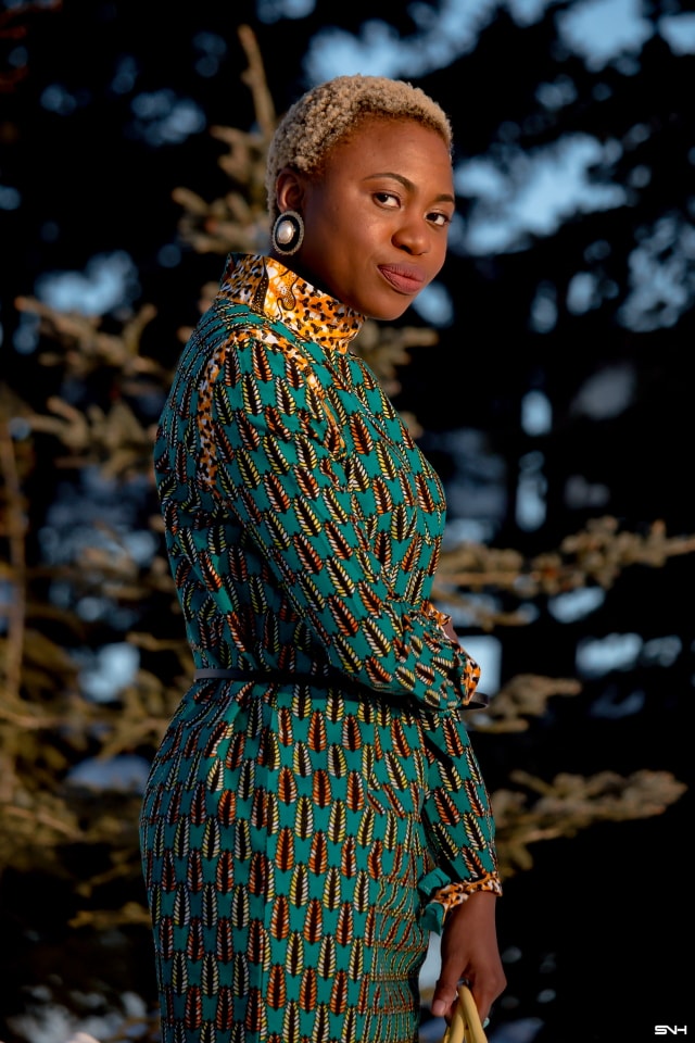 African style blogger, Louisa showcases stylish African print clothes in an epic 30-day series. Day 21 knocks our socks off in a breathtaking belted ankara office dress by Maggie Gold. This conservative office wear shows how versatile African attires are for everyday looks. She finishes off the look with a structured luggage purse, patent classic heels, and trendy lace ankle socks. Check it out! #ankara #dashiki #kente