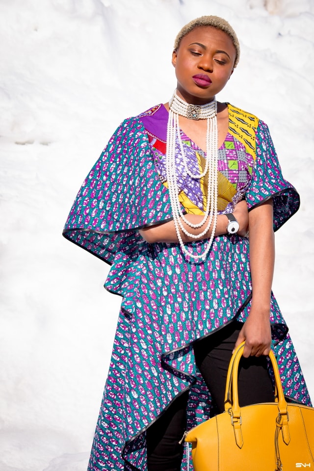 To say that African print clothes are fascinating is an understatement. This tiered African print high low top is the perfect statement blouse this summer. The rich purple, yellow and blue colors paired with fitted black denim and a vibrant satchel is a winner. Can't get enough! Check out this blogger's 30 days of African print fashion! #ankara #africanprint #ankarafashion #nigerian Dashiki, African print dress, African fashion, African women dresses, African prints, Nigerian style