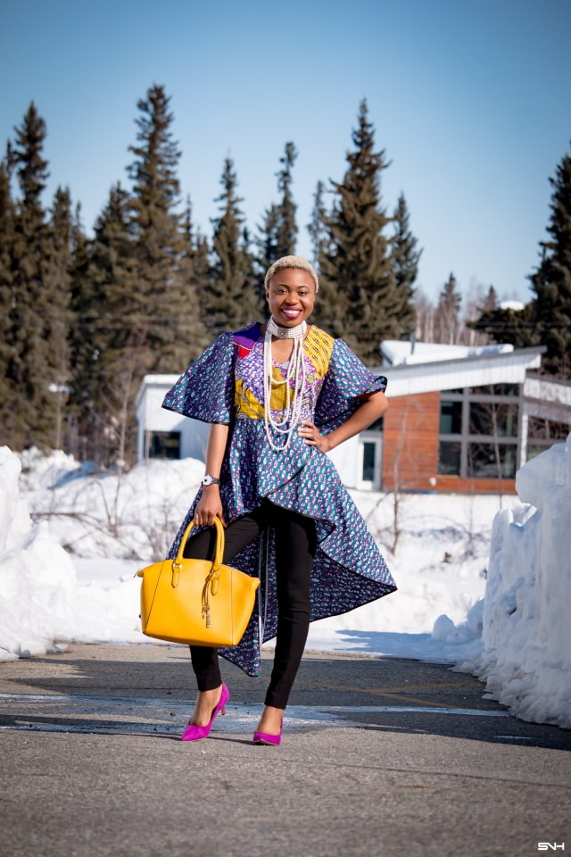 To say that African print clothes are fascinating is an understatement. This tiered African print high low top is the perfect statement blouse this summer. The rich purple, yellow and blue colors paired with fitted black denim and a vibrant satchel is a winner. Can't get enough! Check out this blogger's 30 days of African print fashion! #ankara #africanprint #ankarafashion #nigerian Dashiki, African print dress, African fashion, African women dresses, African prints, Nigerian style