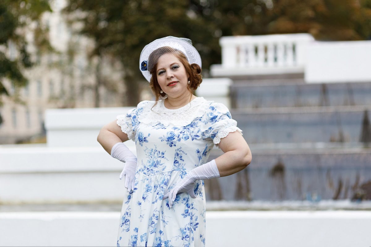 a woman in vintage clothes in the background of a 2024 11 08 18 25 14 utc