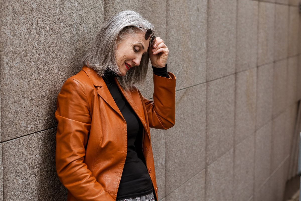 grey senior woman in leather jacket smiling while 2023 11 27 05 21 59 utc