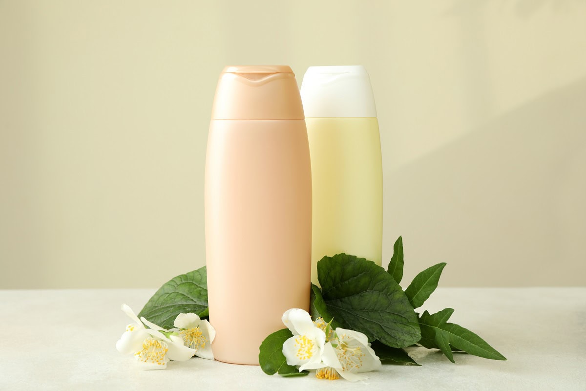 blank bottles of shampoo and flowers against beige 2025 03 26 23 59 03 utc