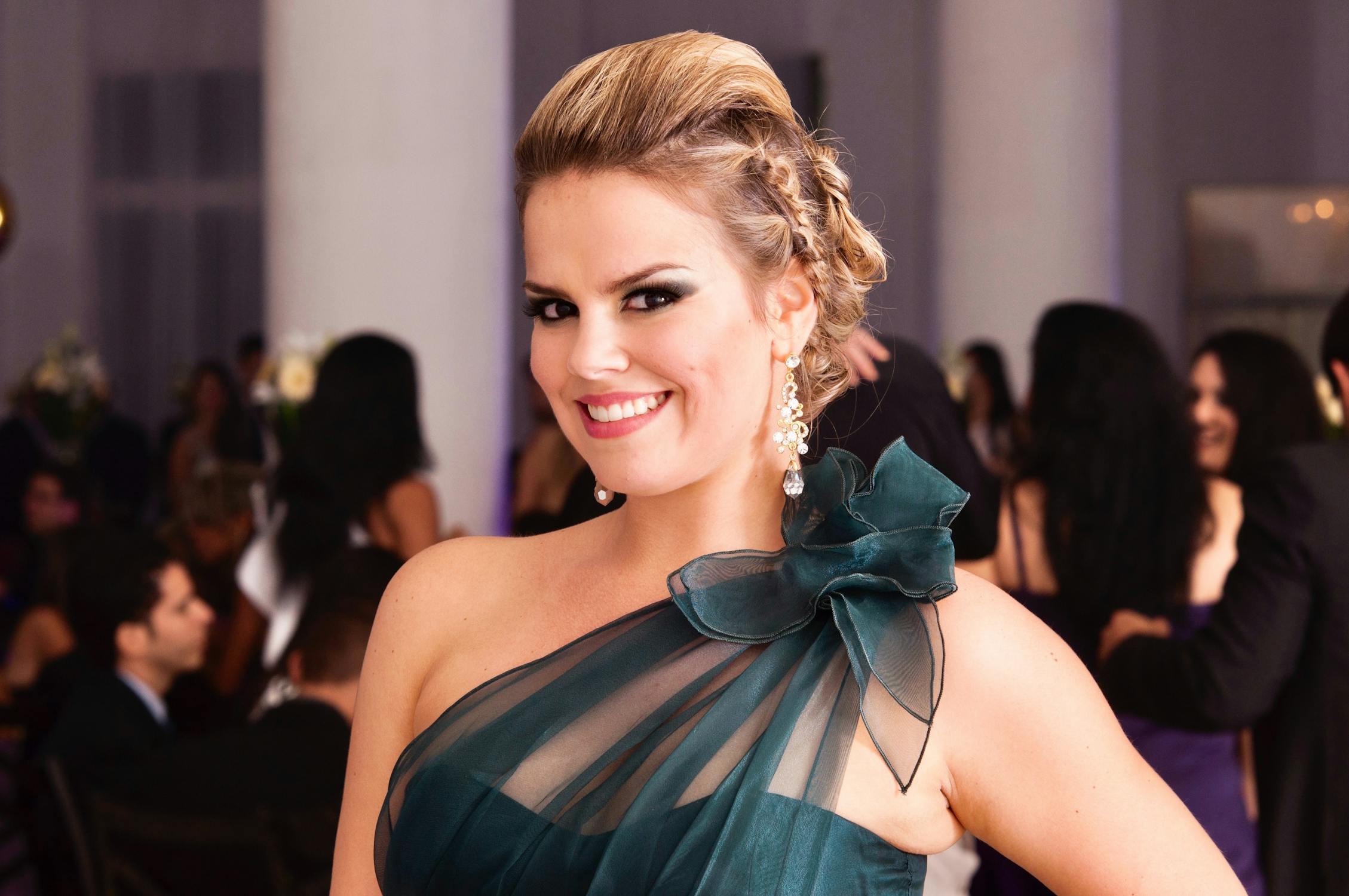 free photo of an elegant woman in a gown standing in a room at a party