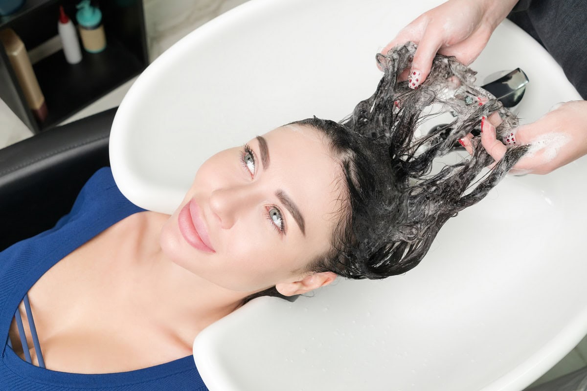 hairstylist s hands wash long hair of brunette wom 2025 02 12 03 33 49 utc