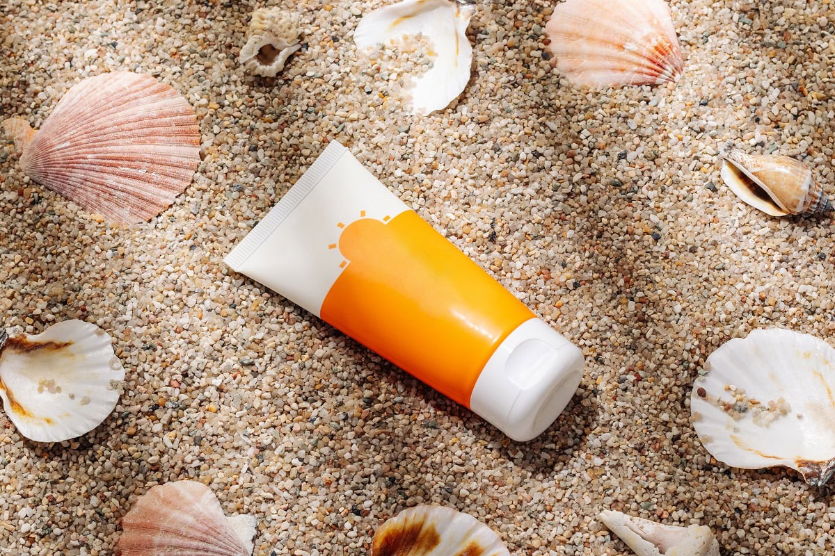 orange tube of sunscreen on sandy beach top view 2025 01 09 02 22 35 utc