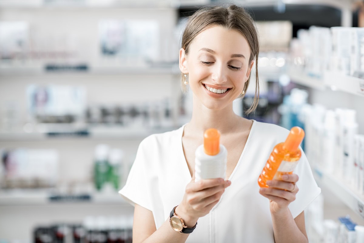 woman choosing sunscreen lotion at the pharmacy 2025 03 13 23 52 34 utc