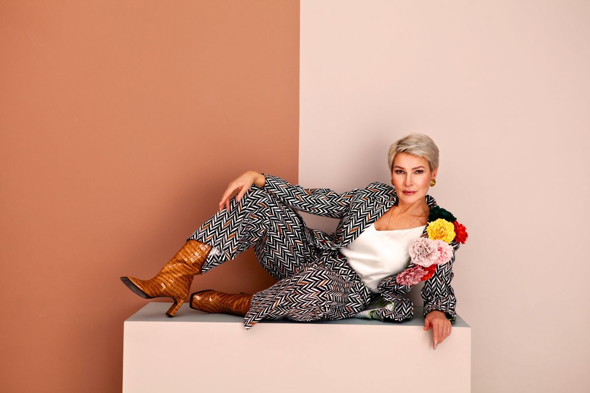 fashionable mature woman lying in studio on brown 2025 01 16 11 54 17 utc
