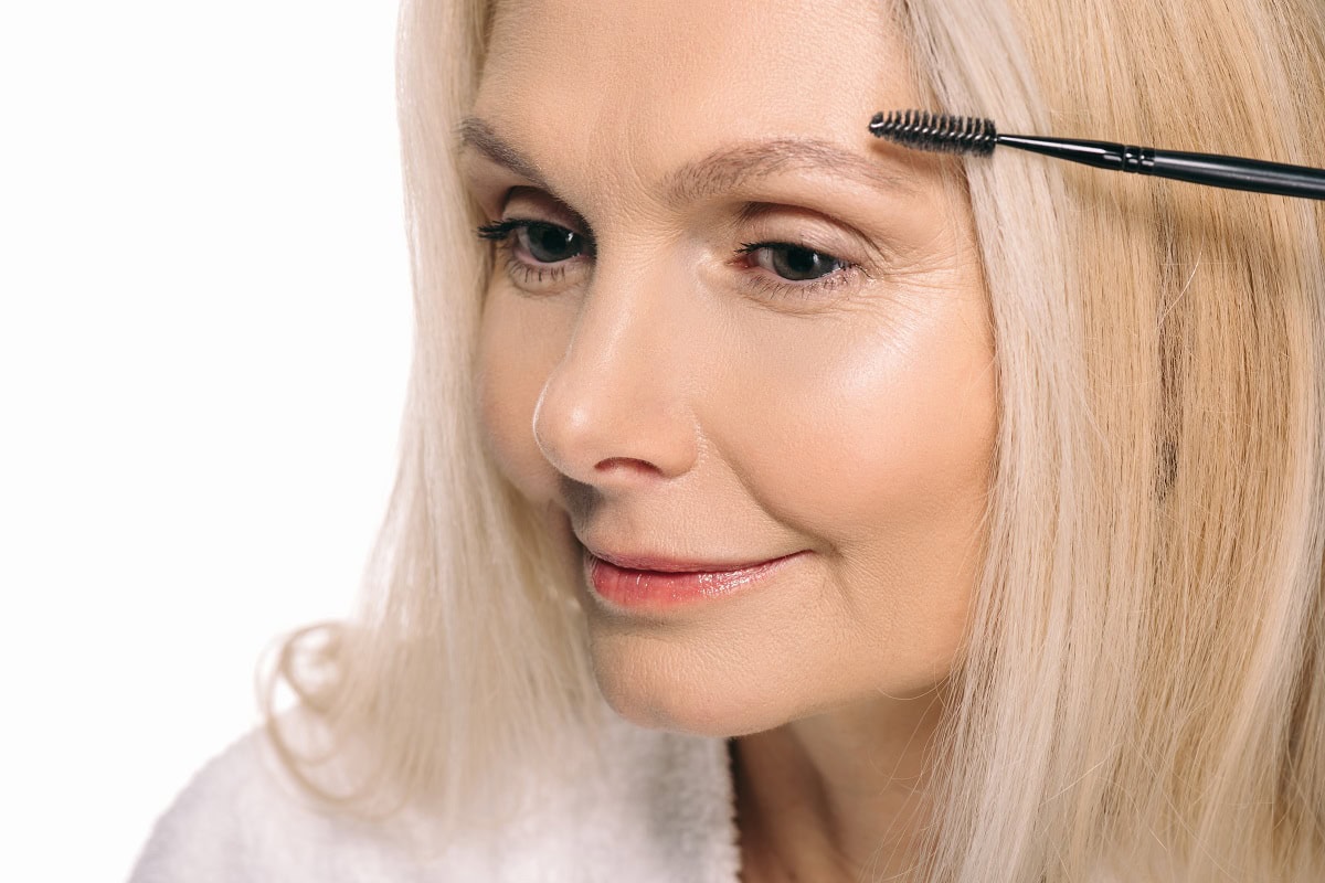 happy mature woman using eyebrow brush isolated on 2024 11 11 04 19 19 utc