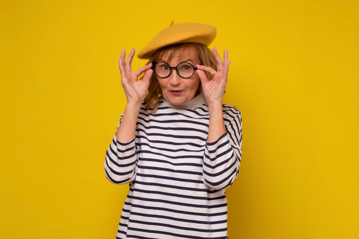 middle age woman in yellow hat and glasses smiling 2024 10 11 13 31 39 utc