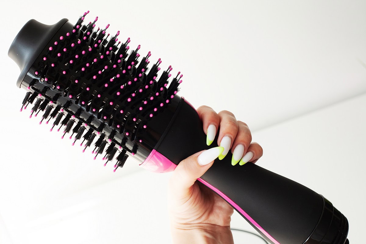 waoman holding hair dryer with and round brush 2025 02 12 05 18 08 utc
