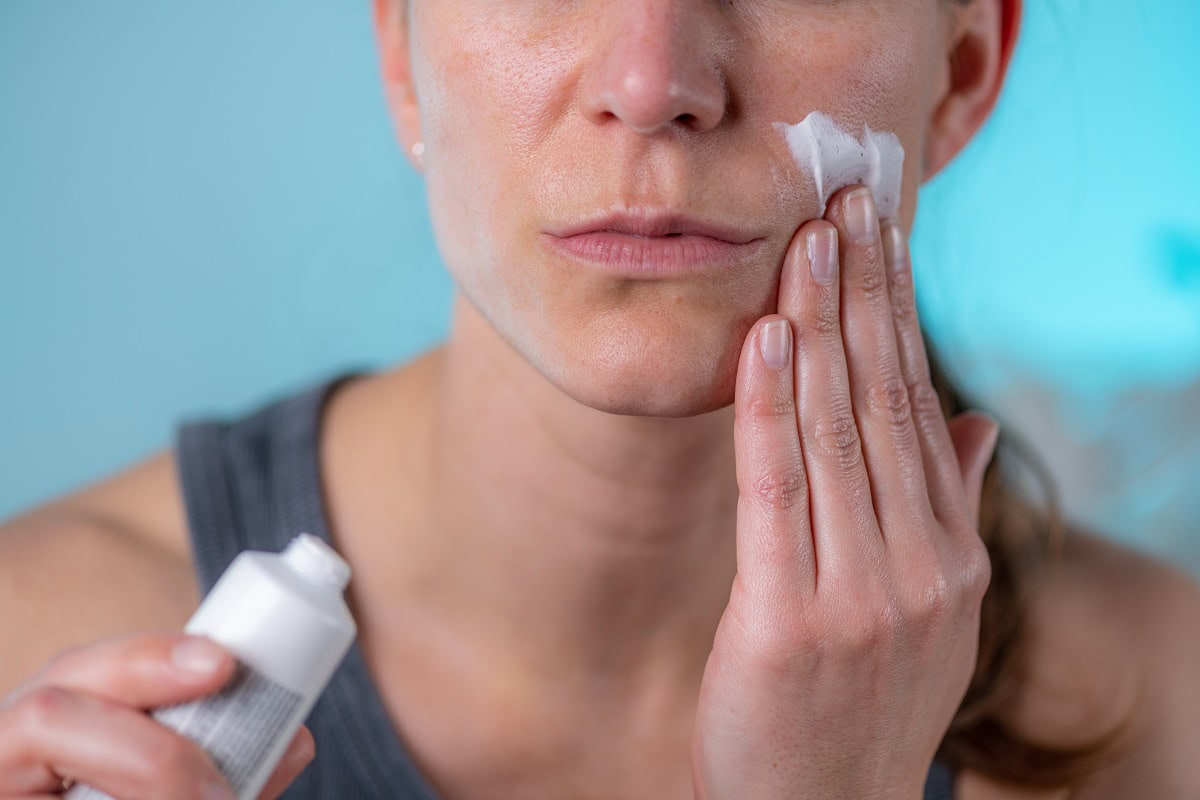woman applies cream to her face at home 2024 10 18 09 31 44 utc