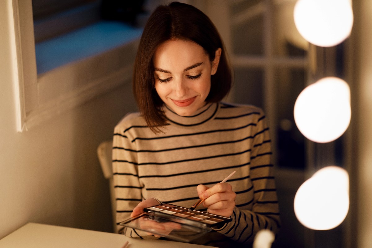 Woman applying make up highlighter