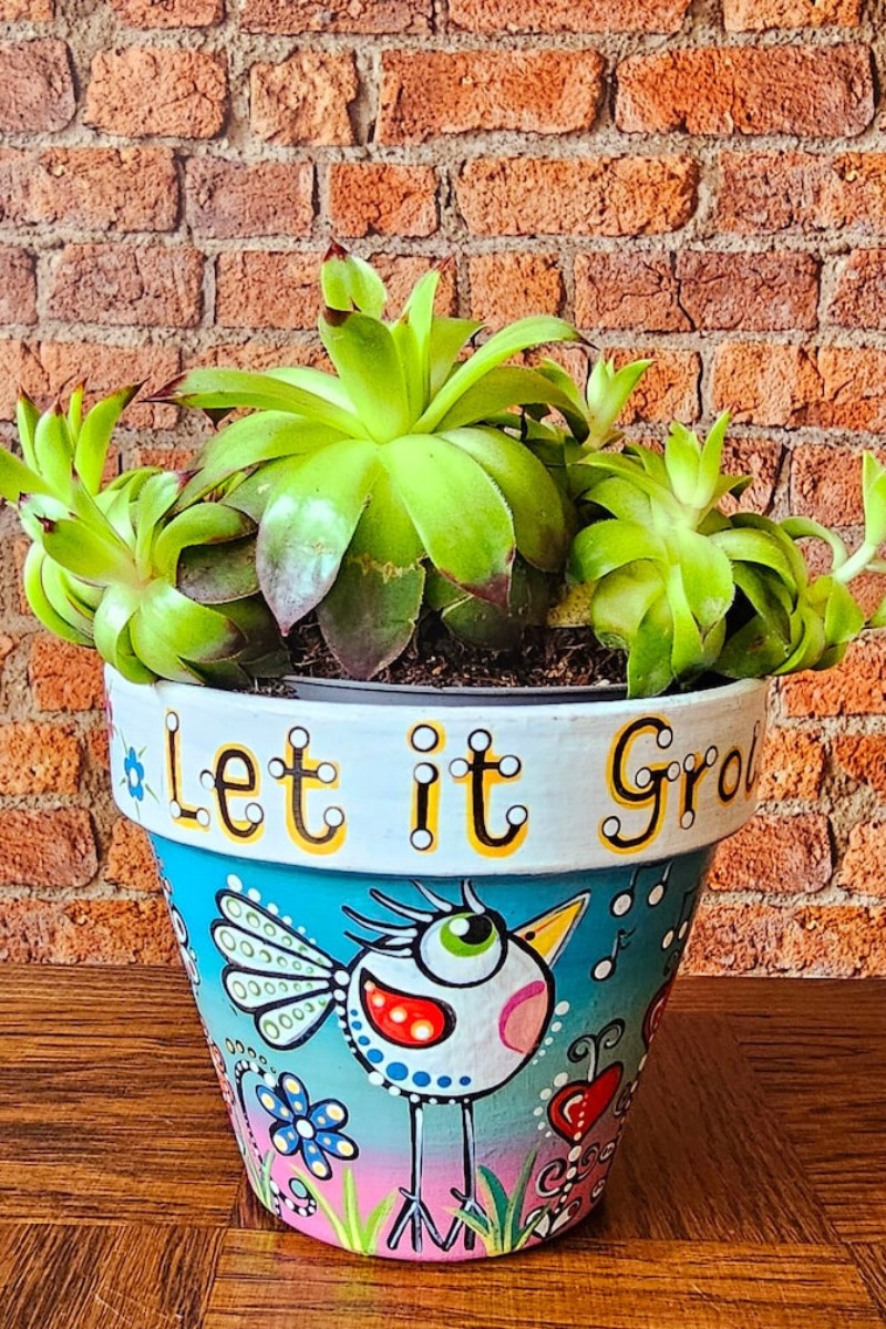 Hand painted terracotta plant pot with green friend